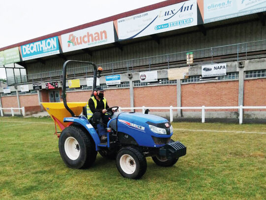 Agent municipal qui entretient la pelouse du stade Jean Bouin au volant d'un tracteur