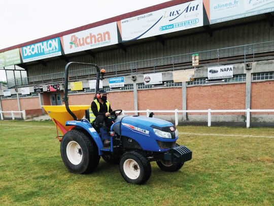 Agent municipal qui entretient la pelouse du stade Jean Bouin au volant d'un tracteur
